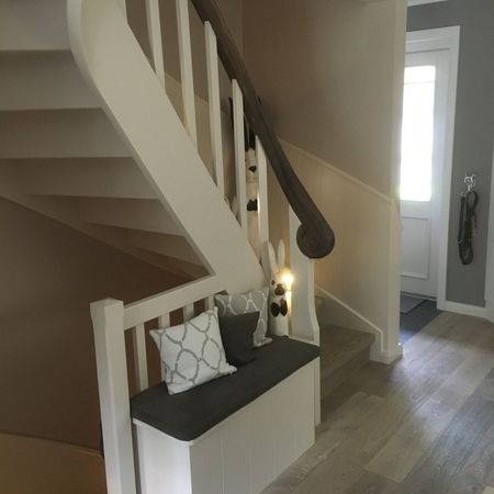 Weiße Holztreppe mit grauem Handlauf