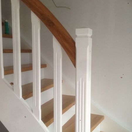 Weiße Holztreppe mit braunem Handlauf