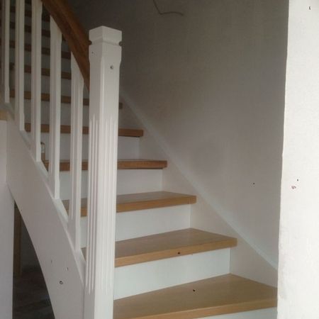Weiße Holztreppe mit braunem Handlauf