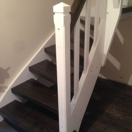 Dunkle Holztreppe mit hellem Geländer und dunklem Handlauf