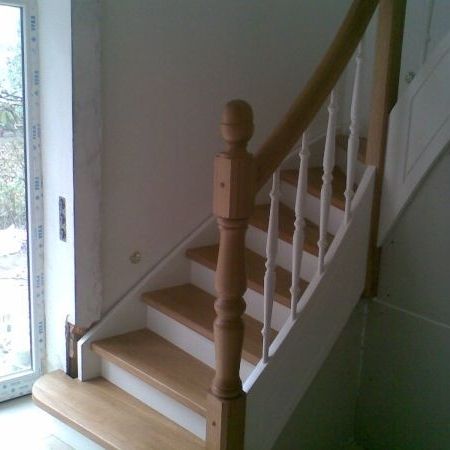Weiße Holztreppe mit braunem Handlauf