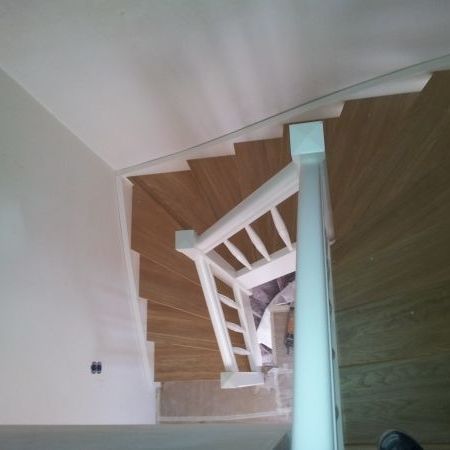 Holztreppe mit dunklen Stufen und weißem Geländer